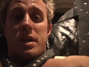 Dean Coxx dressed in leather plays with a a big black dildo in a sex swing before shooting a big load all over himself.